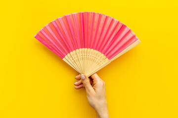 Hand fan made of bamboo and paper in female hand