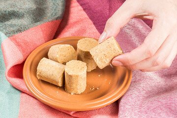 June Celebration. Sweet Brazilian peanut called Paçoca on a plate on a colored fabric