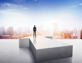 Vision concept. Successful businessman standing on arrow and looking over city