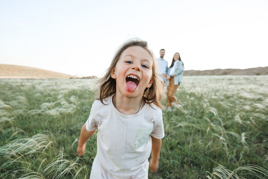 A hipster family walks in a summer field.