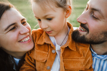 A hipster family walks in a summer field.