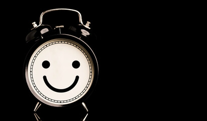 Smiley face inside of alarm clock on black background and copy space, happiness and mindset concept. - obrazy, fototapety, plakaty