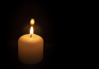 Light from a wax candle burning in the dark