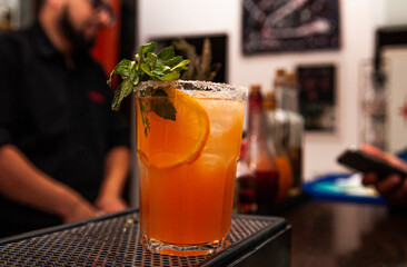 Primer plano de cocktail con detalles en Menta y naranja