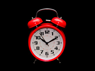 A red clock isolated on a black background.