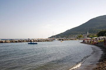 Breakwater and mole with the mount Bulgheria in the background at sunset. Scario village in the...