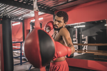 African american kickboxer having a workout in a gym and looking concentrated