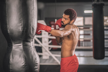 African american kickboxer exercising in a gym working on his kicks