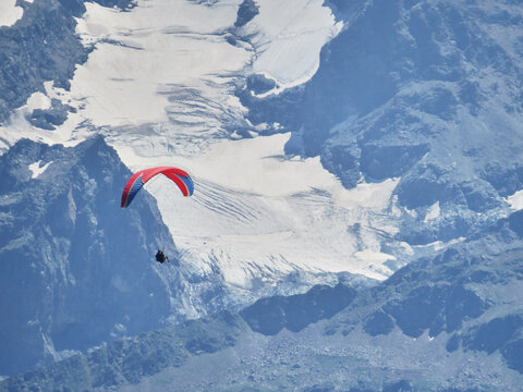 Paraglider flying through the mountains