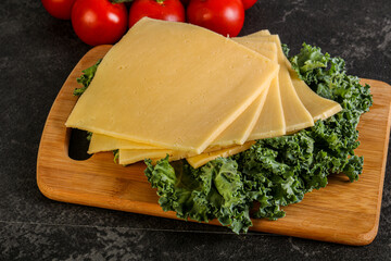 Sliced Gauda cheese over board