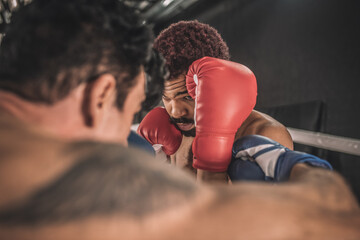 Two kickboxers fighting on a boxing ring and looking aggressive