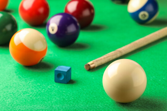 Classic white billiard ball on green table, closeup. Space for text