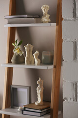 Beautiful David bust and body shaped candles on rack indoors