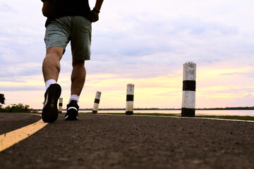 person running on the road at sunset.