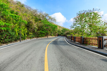 Empty asphalt road and mountain scenery on sunny day.