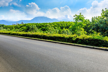 Empty asphalt road and mountain scenery on sunny day.