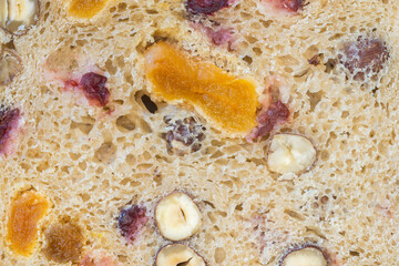 A texture of rye bread slice with cranberry raisin, apricot and hazelnuts