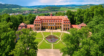 Aerial view of classicist chateau of French style. Large chateau, built by Salm noble family, surrounded by park, trees and hills. Summer, Rájec nad Svitavou, traveling Czech republic.