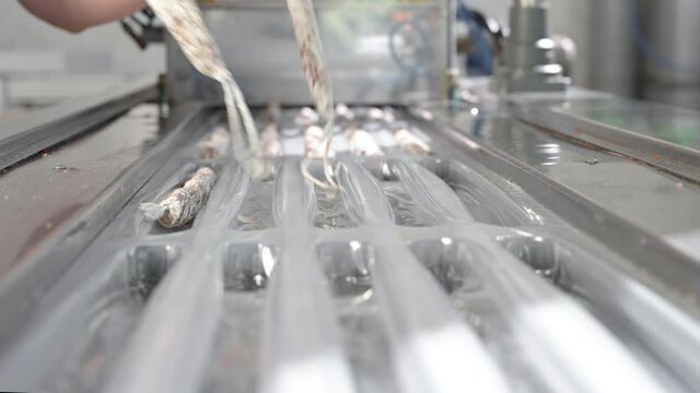 Sausages. Packing line of sausages Fuet is a Catalan thin, cured, dry sausage of pork meat in a pork gut . Industrial manufacture of sausage products. High quality 4k footage