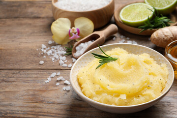 Body scrub with rosemary in bowl on wooden table, space for text
