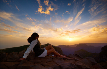 Woman watching dramatic sunset over mountains of Madeira Island. Pico do Arieiro, Madeira Island,...