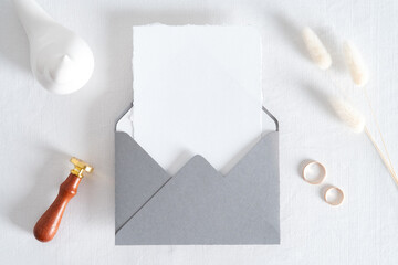 Elegant wedding stationery mockup scene. Blank invitation card, grey envelope with wax seal stamp,...
