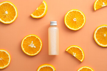 Cosmetic bottle with serum and orange slices. Flat lay, top view.