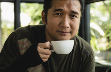 Portrait of Asia middle-aged man drinking coffee at the cafe