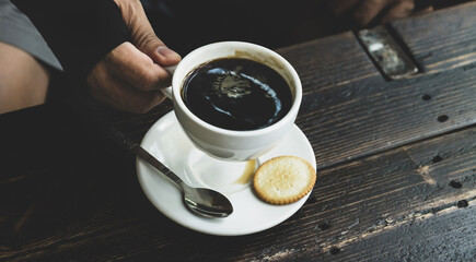Portrait of Asia middle-aged man hand holdimg for drinking coffee at the cafe