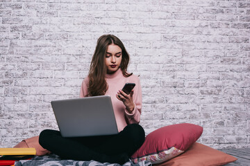 Pensive woman with laptop and smartphone