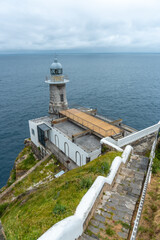 Fototapeta na wymiar Santa Catalina de Lekeitio lighthouse on a cloudy spring morning, with the sea in the background, landscapes of Bizkaia. Basque Country