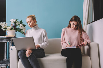 Thoughtful women with laptop and notebook