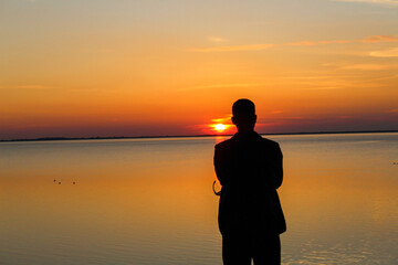 Fototapeta premium A man watches a sunset on the North Sea