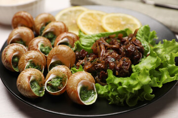 Delicious cooked snails served on white table, closeup