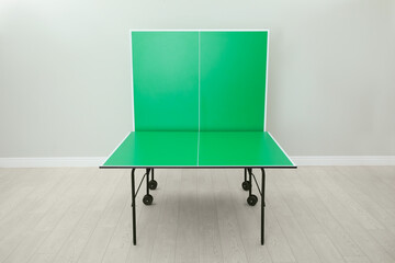 One folding green ping pong table indoors