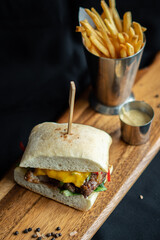 Steak Sandwich with french fries and mustard mayo on wooden board