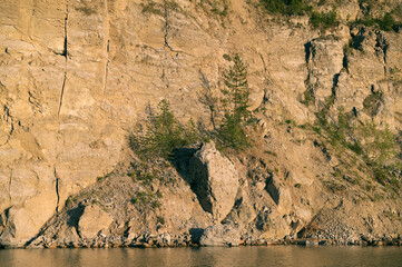 Fototapeta na wymiar Rocky, steep bank of the Kama River, Perm region, reflection in the water.