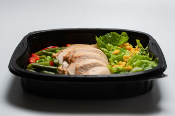 Ready food in a container. Stewed chicken, stewed vegetables.