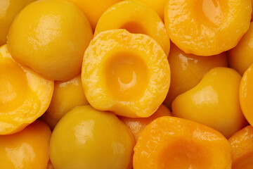 Halves of canned peaches as background, top view