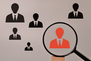 Headhunting and choosing good employee concept. Red employee icon with magnifying glass.