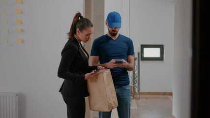 Businesswoman receiving order box takeaway food at workplace paying lunch transaction with smartphone using POS service contactless. Delivery guy bringing meal purchase to entrepreneur client
