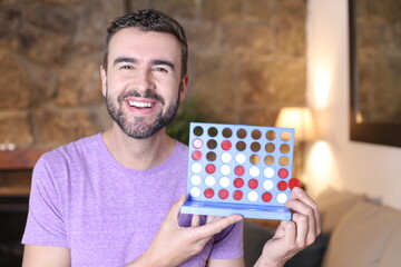 Guy showing traditional connect four chips game