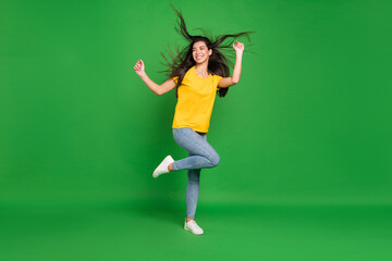 Full length body size photo girl with long brunette hair dancing at party looking copyspace isolated vivid green color background