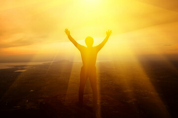 Man raising his arms to thank God on the mountain