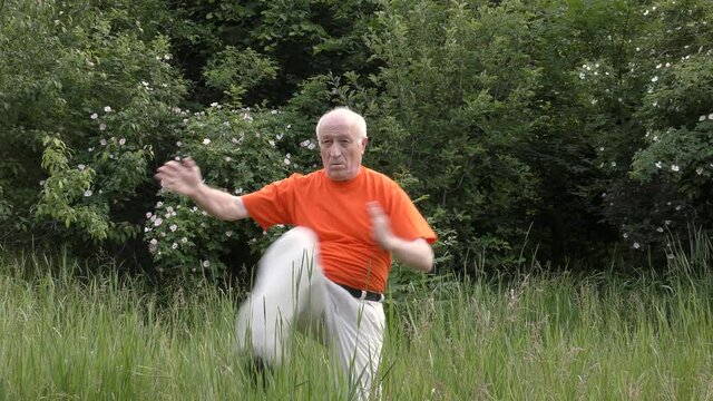 Old man athlete training kicks exercises