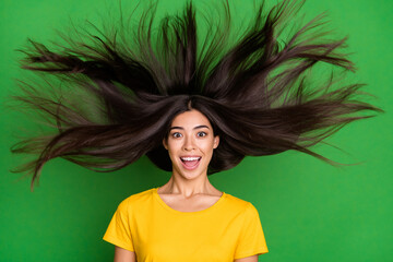 Photo of amazed happy excited young woman fly hair sale surprised new isolated on green color background