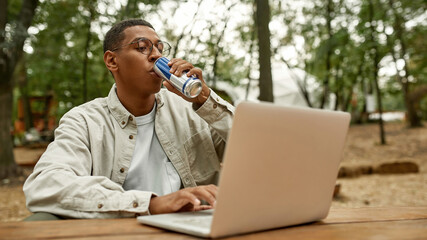 Happy young african american man drinking energy drink