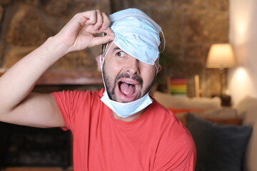 Exaggerated man covering his head with surgical masks 