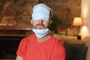 Exaggerated man covering his head with surgical masks