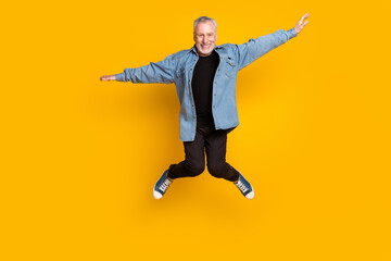 Full size photo of optimistic granddad jump wear jacket pants sneakers isolated on yellow color background